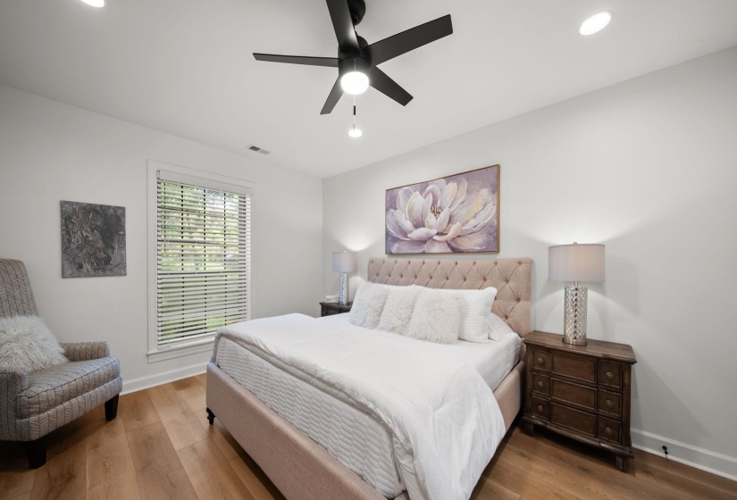 Spacious room featuring wood-finish flooring, recessed lighting, and a modern ceiling fan