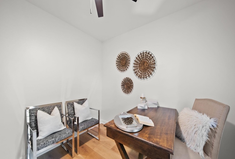 Dedicated room featuring light-toned walls, wood-finish flooring, and a ceiling fan