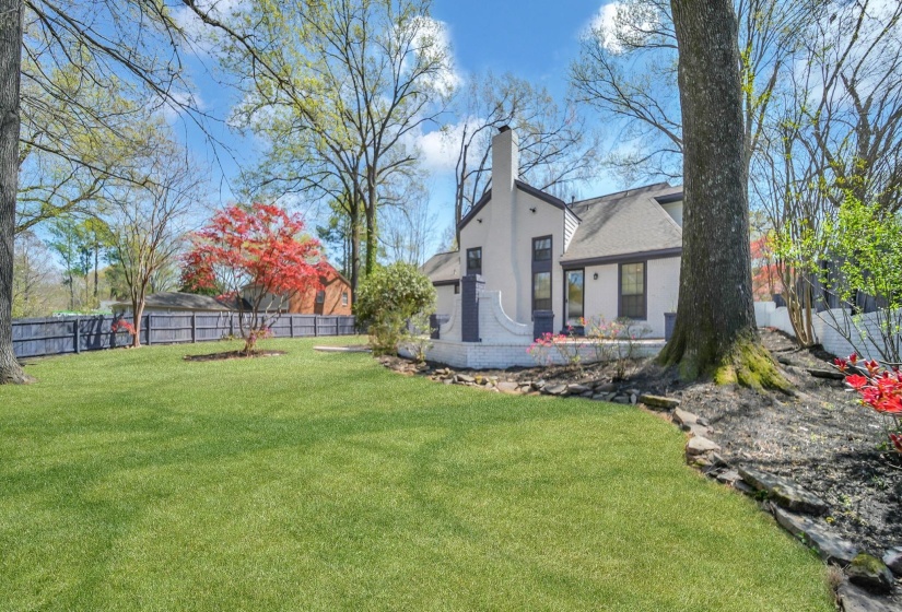 Rear view of property featuring a fenced backyard, stucco siding, and a chimney