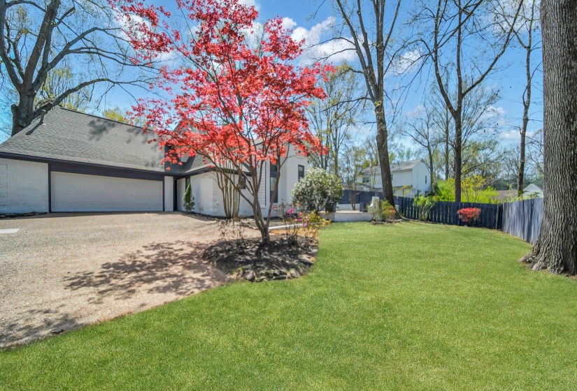 View of yard featuring driveway and a garage