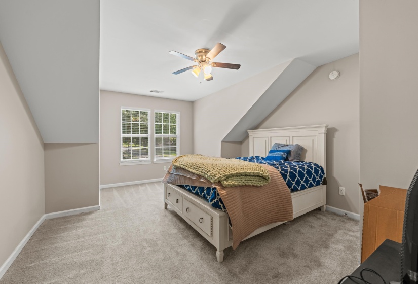 Carpeted room featuring a sloped ceiling and dual-pane windows