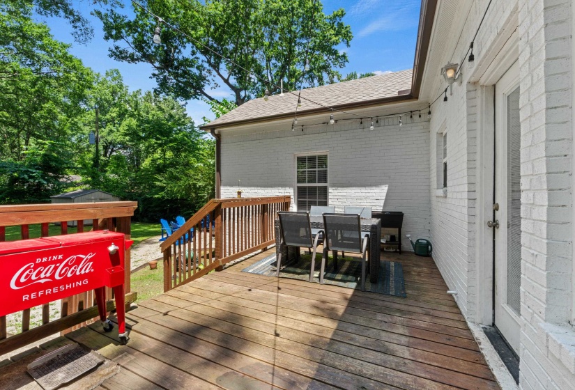Expansive wooden deck with railing and stairs to the yard