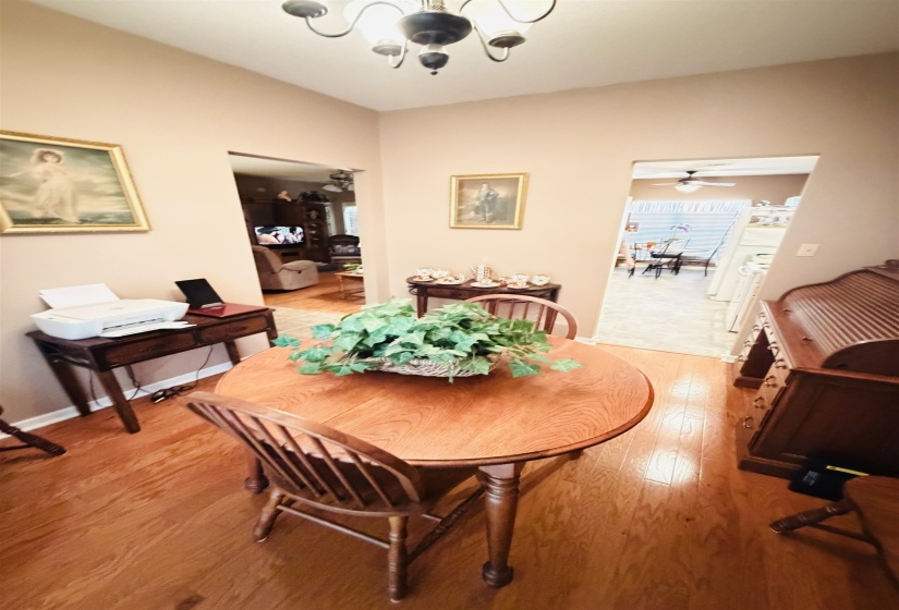 Hardwood-style flooring extends throughout this interior space, illuminated by an overhead chandelier