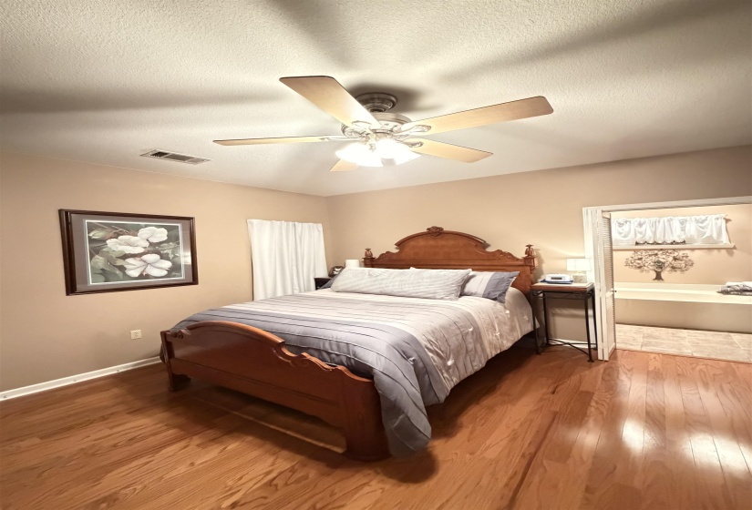 Wood-finish flooring with a ceiling fan overhead