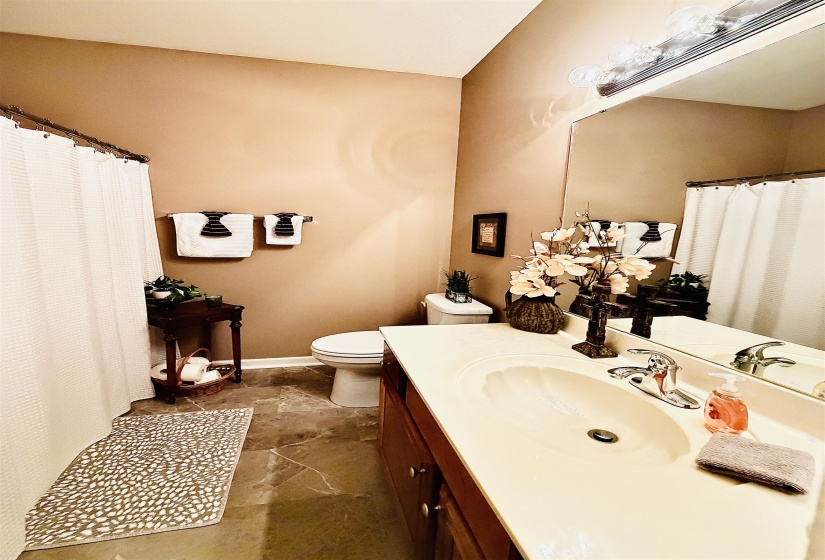 Full vanity with integrated sink, chrome faucet, and a large wall-mounted mirror