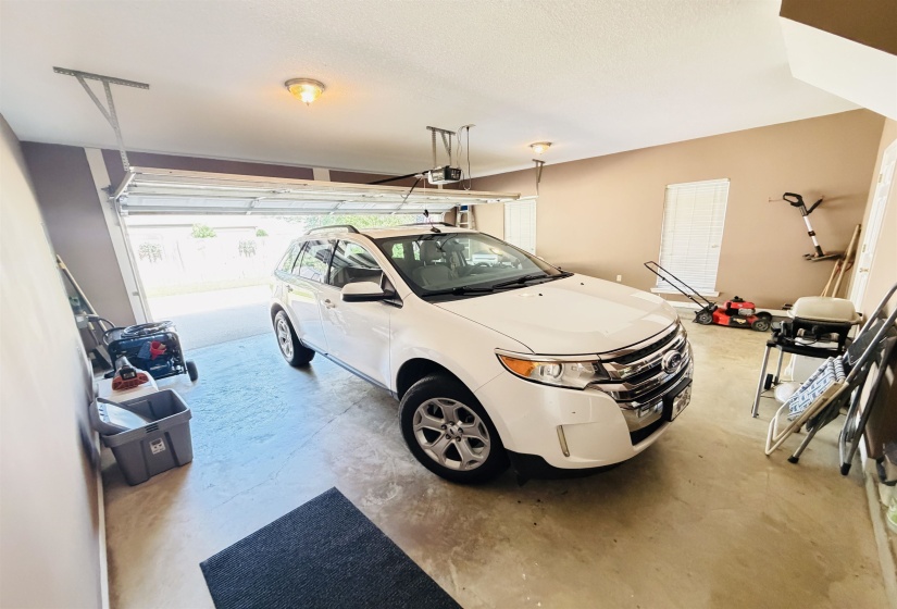 Two-car garage featuring a concrete floor, light neutral wall paint, and a white overhead garage door