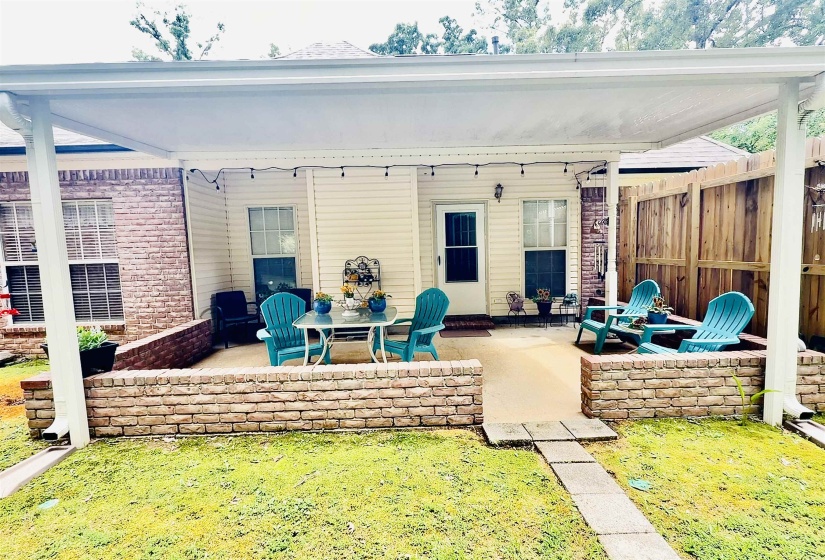 Covered patio area featuring a concrete surface and brick knee walls
