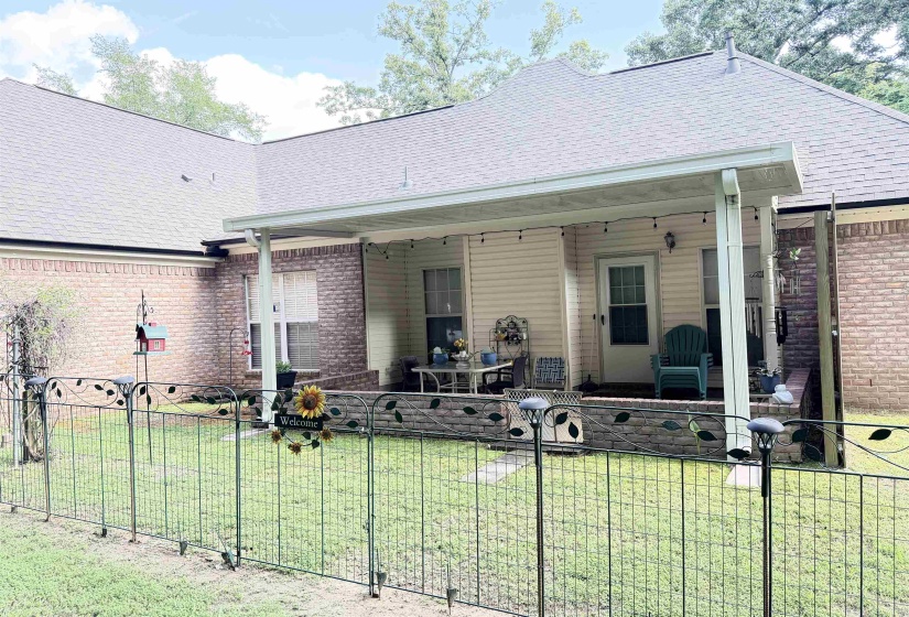 Covered patio with string lighting and a durable brick and siding exterior