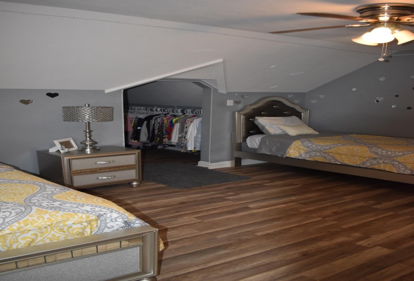 Wood-finish flooring provides a warm aesthetic in this room featuring a built-in closet area