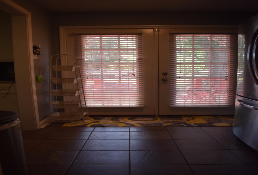 Tile flooring extends through this space, featuring double French doors with blinds