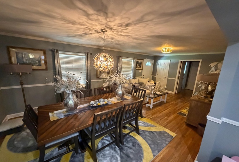 Formal dining area featuring a decorative chandelier, wood-finish flooring, and crown molding