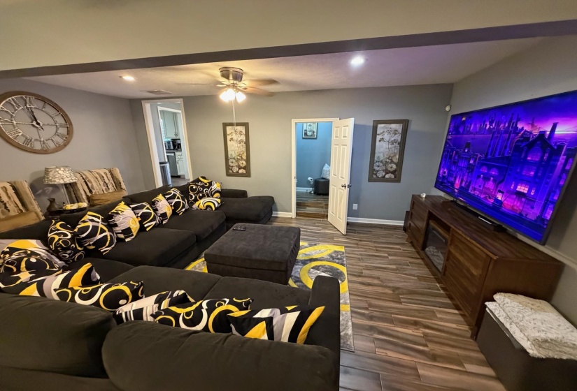 Living area featuring wood-finish tile flooring, recessed lighting, and a ceiling fan
