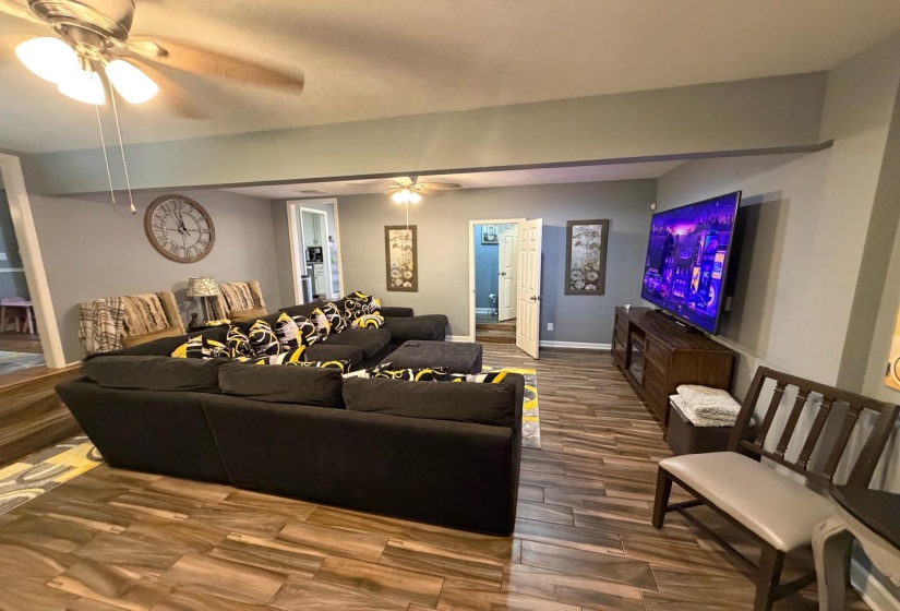 Spacious room with wood-finish flooring, two ceiling fans, and neutral wall tones