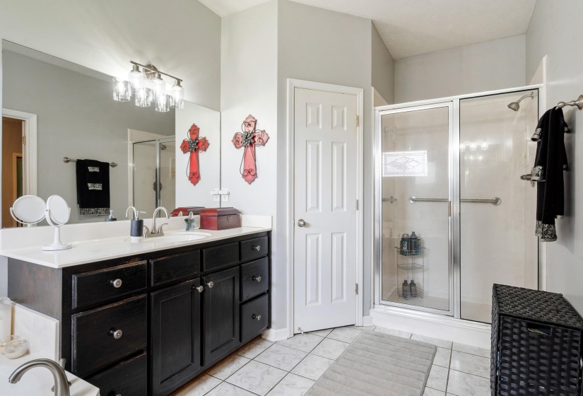 Bathroom featuring a spacious double vanity with dark cabinetry and a light-colored countertop