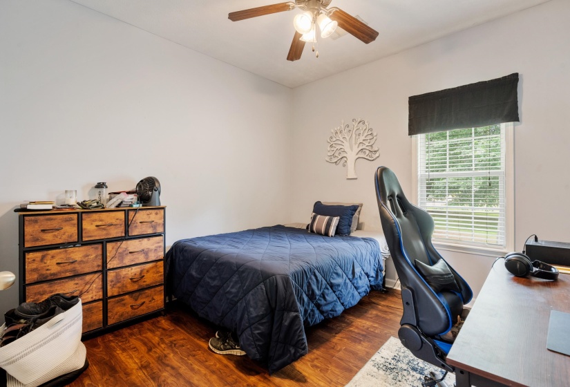 Bright room with wood-finish flooring, a ceiling fan with integrated lighting, and a window with blinds