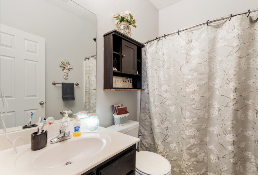 Bathroom featuring a single vanity with an integrated sink, a rectangular mirror, and a wall-mounted towel bar