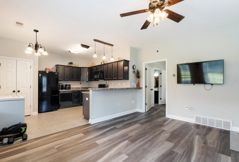 Spacious open-concept area featuring wood-finish flooring