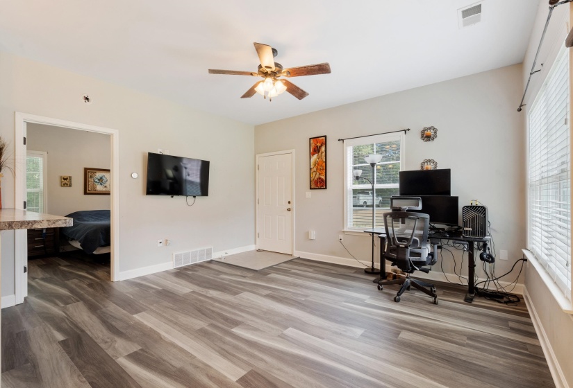 Living area featuring wood-finish flooring, a ceiling fan, and light gray wall paint