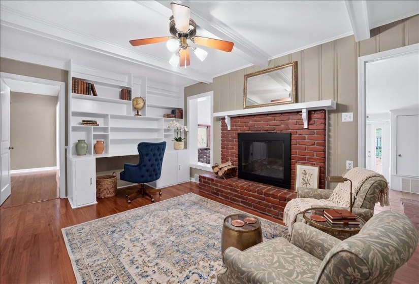 Hardwood-finish flooring complementing a brick fireplace with a white mantel and hearth