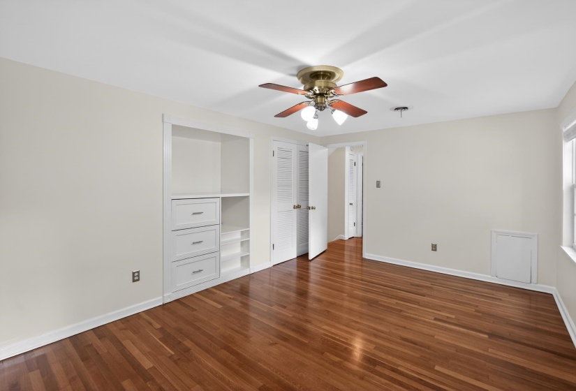 Wood-finish flooring throughout, featuring a built-in storage unit with drawers and shelving