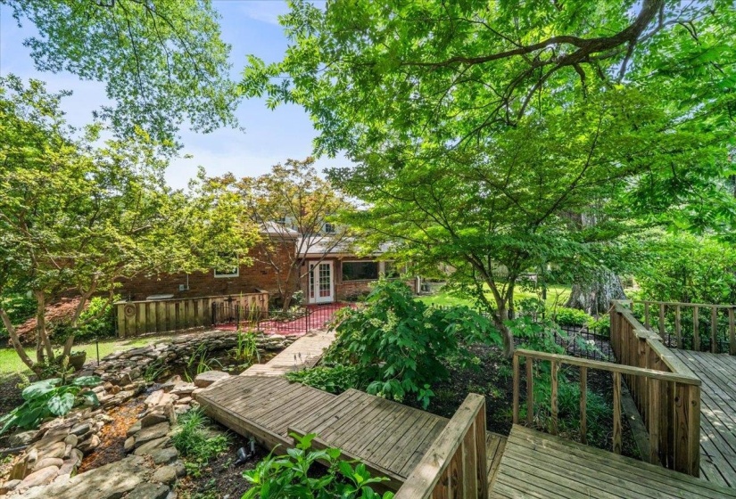 Multi-level wood deck overlooking a rock garden with water feature