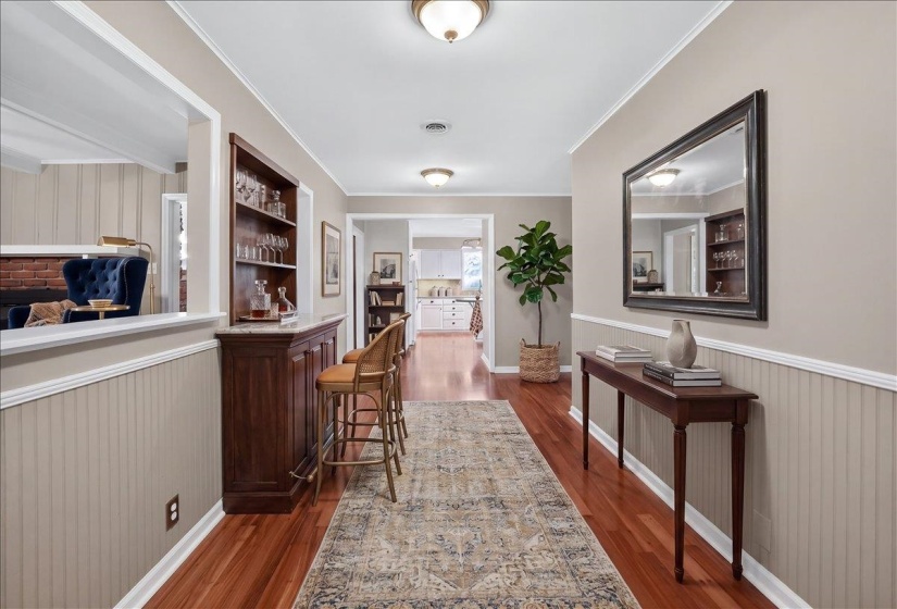Hallway featuring wood-finish flooring, beadboard wainscoting, and recessed lighting