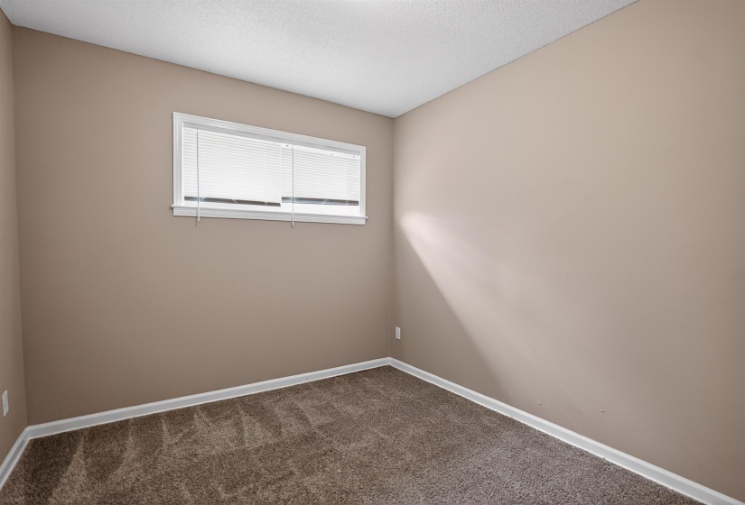 Neutral-toned room featuring a single window with blinds