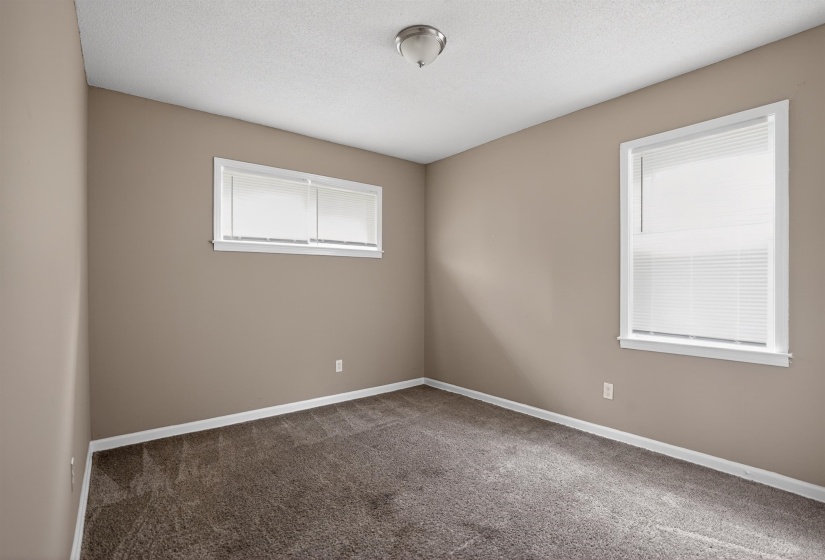 Neutral-toned walls complement plush carpet flooring