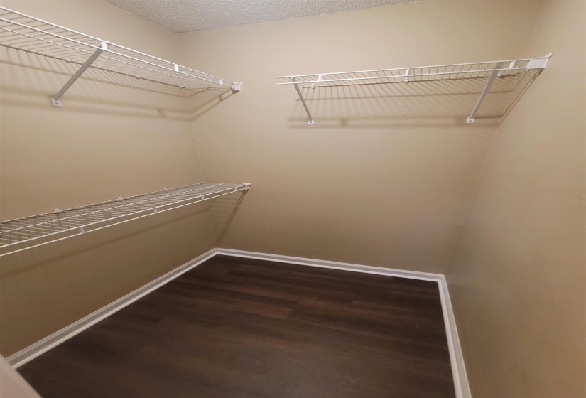 Storage area featuring wire shelving, wood-finish flooring, and neutral wall tones