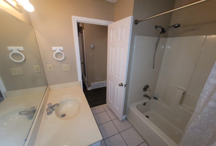 Bathroom featuring a white vanity with an integrated sink, chrome faucet, and expansive wall mirror