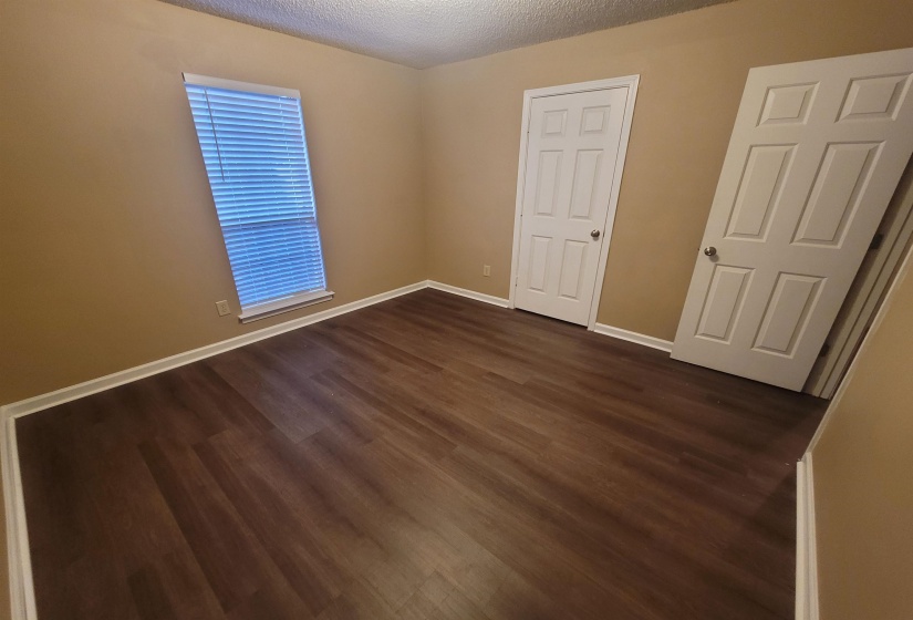Room featuring wood-finish flooring, neutral wall paint, and white baseboards