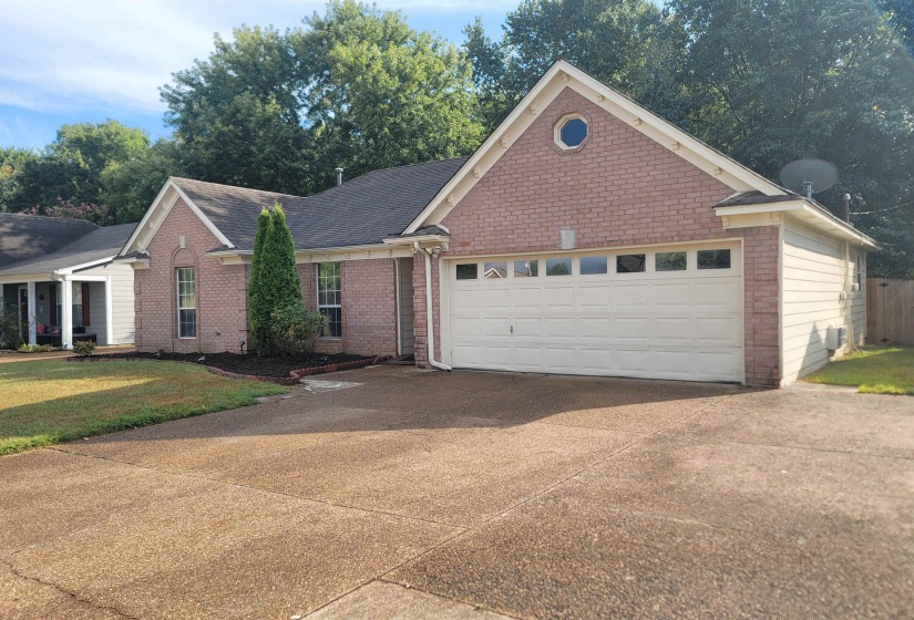 Brick and siding exterior featuring a two-car garage with transom windows
