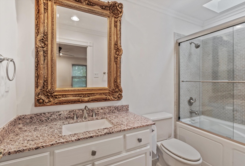 Bathroom featuring a vanity with a speckled countertop, undermount sink, and brushed nickel faucet