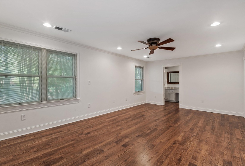 Spacious interior room featuring rich wood-finish flooring, recessed lighting, and a ceiling fan