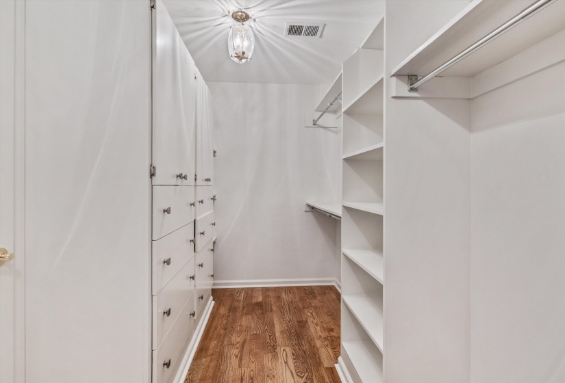 Custom closet system featuring built-in drawers, white cabinetry, and extensive shelving