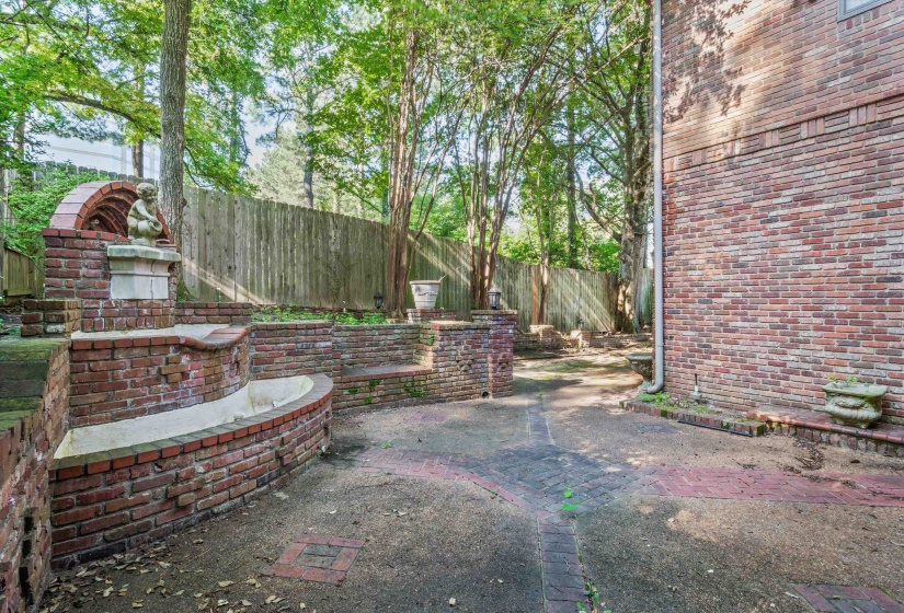 Brick patio featuring a multi-tiered fountain with a statue accent
