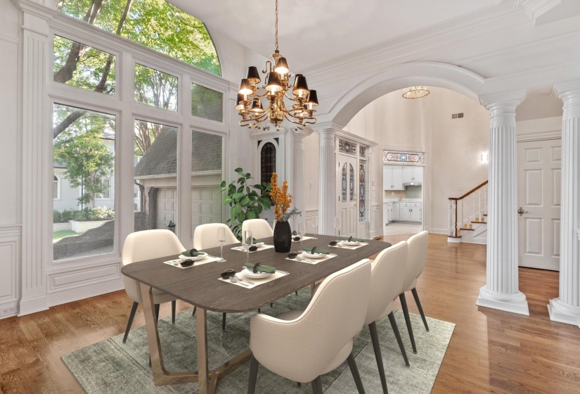 Dining area featuring expansive windows with an arched transom, hardwood flooring, and a chandelier