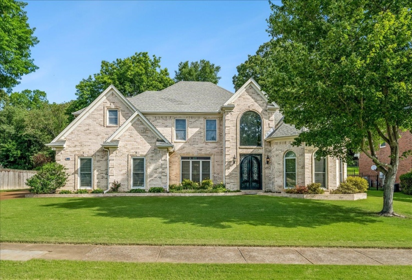 Two-story brick exterior with an arched entry and double front doors