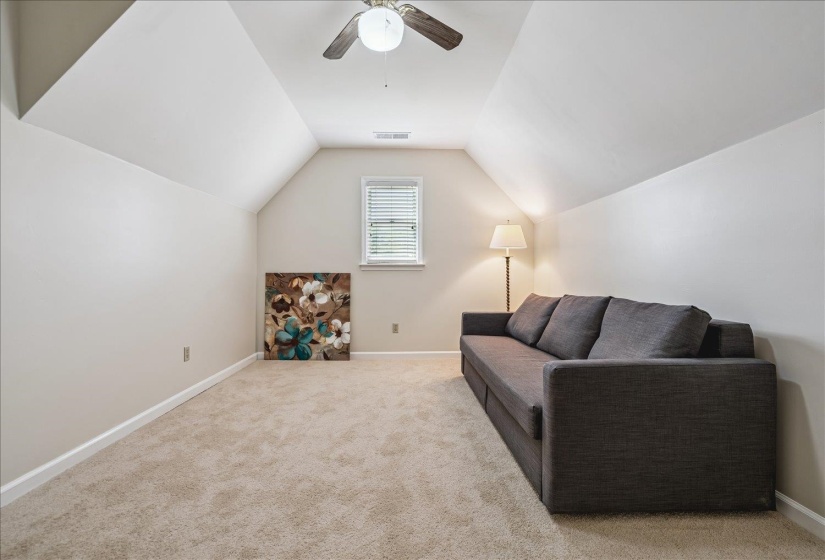 Versatile bonus room featuring neutral carpeting, a ceiling fan, a window with blinds, and sloped ceilings