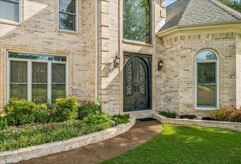 Brick exterior featuring an ornate double-door entry with arched transom