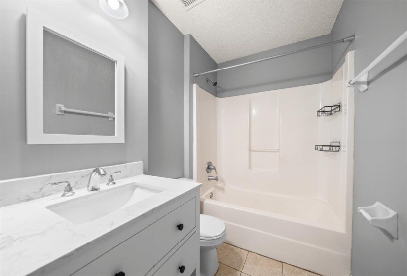 Bathroom featuring a white vanity with a rectangular undermount sink and chrome faucet, set against a light gray wall