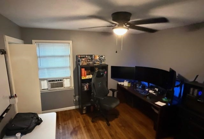 Room featuring wood-finish flooring and a ceiling fan with integrated lighting
