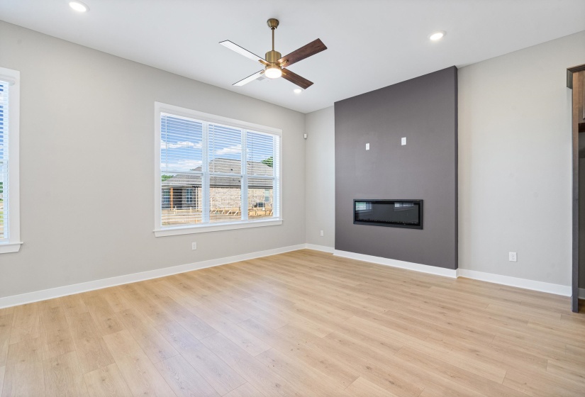 Modern living space featuring a built-in electric fireplace, recessed lighting, and a ceiling fan