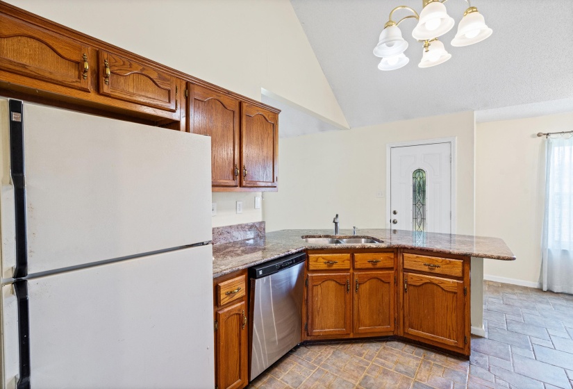 Kitchen featuring wood cabinetry, granite countertops, a stainless steel dishwasher, and a double basin sink