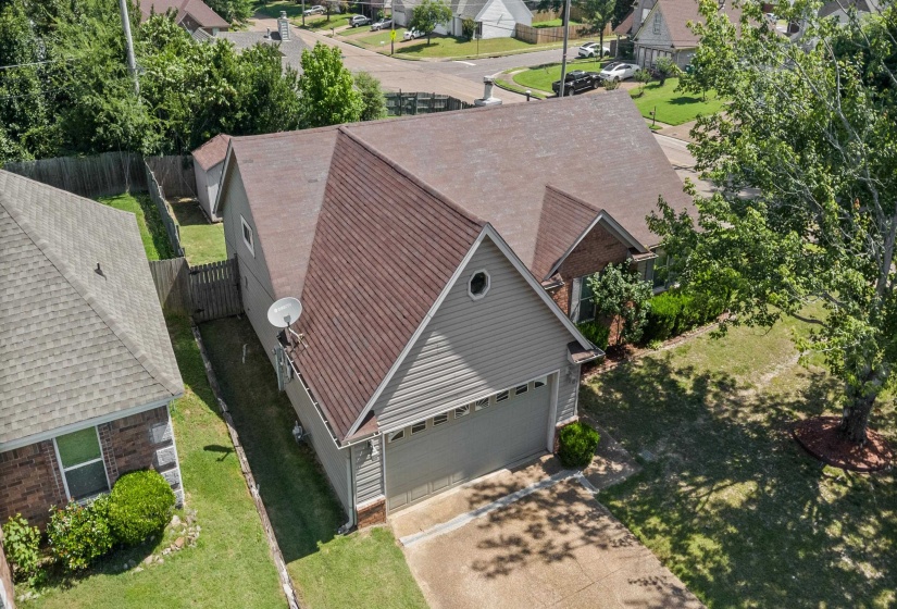 Single-story residence featuring a two-car garage, gray siding, and a brown shingle roof
