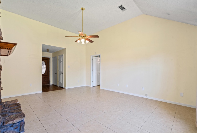 Spacious living area featuring a vaulted ceiling and tile flooring