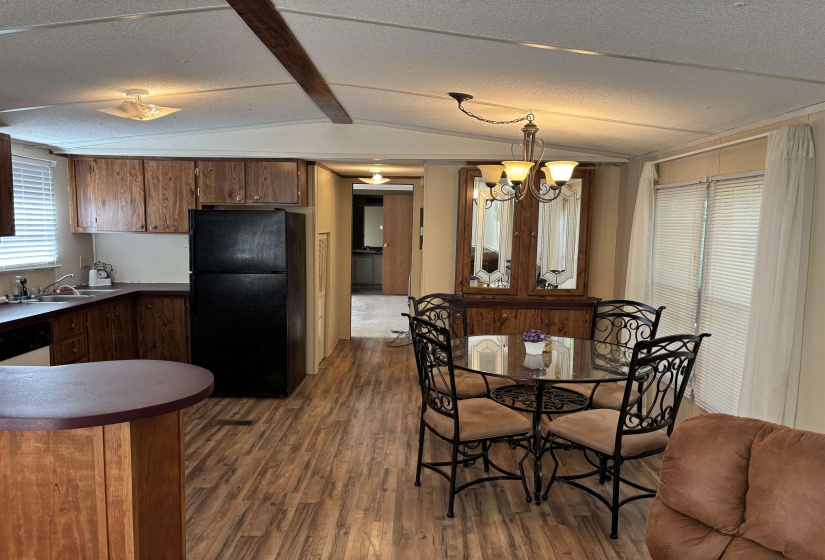 Dining area with dark wood-type flooring, a chandelier, and a textured ceiling