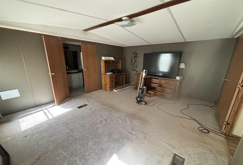 Unfurnished living room featuring lofted ceiling