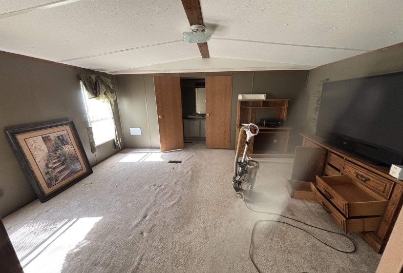 Carpeted living room with a textured ceiling and a ceiling fan