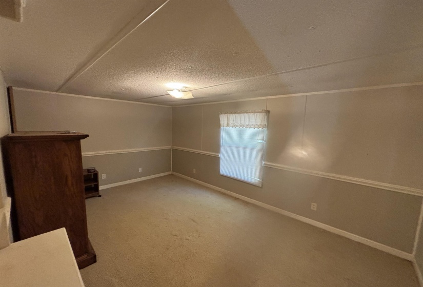 Empty room with carpet floors and a textured ceiling